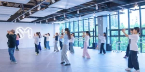K-pop idol training system in action with trainees practicing choreography in SM Entertainment's modern dance studio